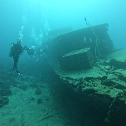 Une photo d'un groupe de plongeurs du centre de plongée de Chloé avec l'épave, lors du cours Advanced Open Water.